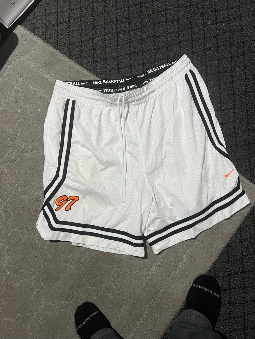 Nike men’s White Basketball Shorts with Black Trim and Orange Accents